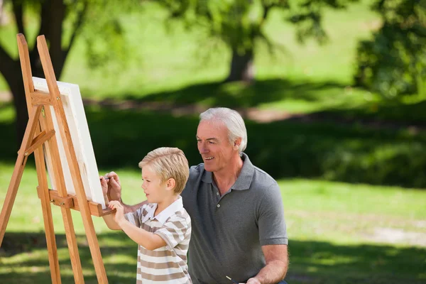 Grand-père et son petit-fils peignent dans le jardin — Photo