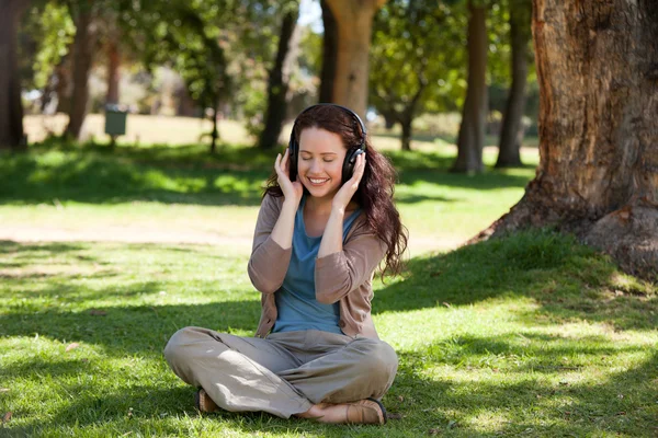 Žena poslouchat nějakou hudbu v zahradě — Stock fotografie