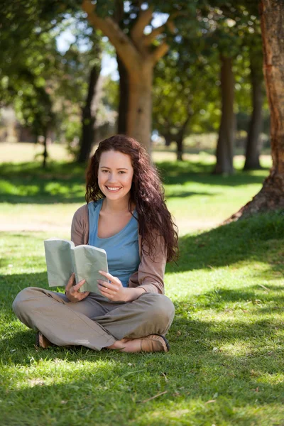 Vrouw die een boek leest in de tuin — Stockfoto