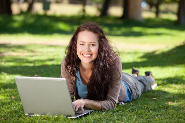 Жінка працює на ноутбуці в парку — стокове фото