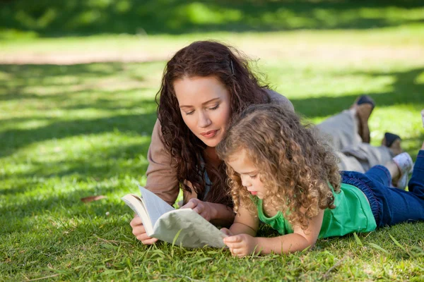Woman with her daughter reading a book — Stock Photo, Image