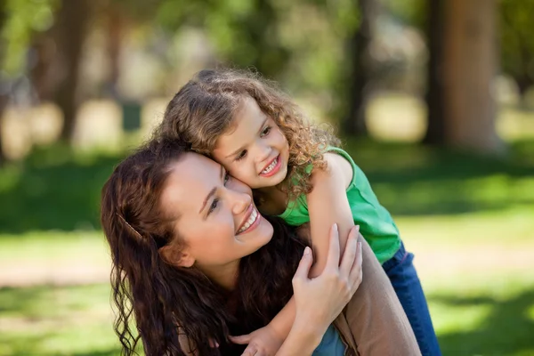 Woman hugging her daughter in the park — Stockfoto