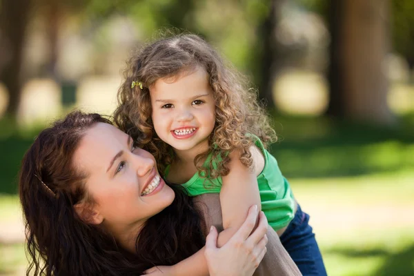 Woman hugging her daughter in the park — Stock Photo, Image