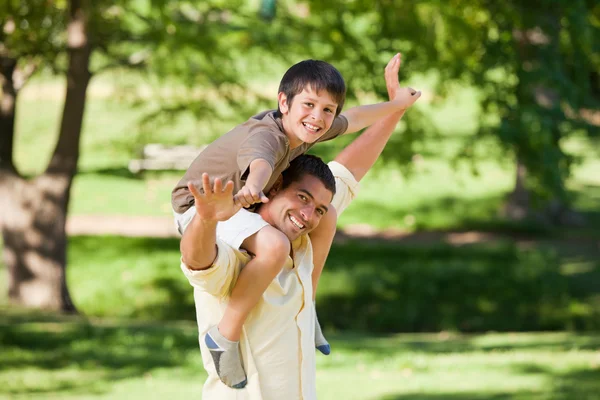 Knappe man geven zoon een piggyback — Stockfoto