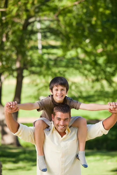 Handsome man giving son a piggyback — Stock Photo, Image