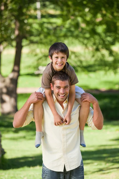 Hombre guapo dando hijo un piggyback — Foto de Stock