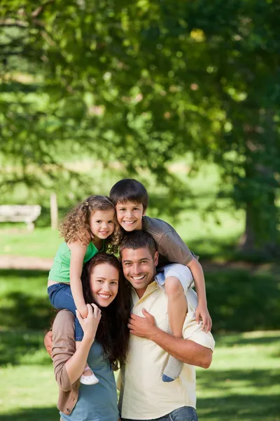 Pais dando às crianças um piggyback — Fotografia de Stock