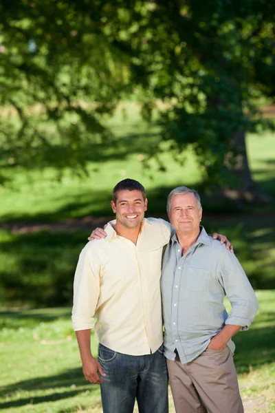 Vater und Sohn blicken im Park in die Kamera — Stockfoto