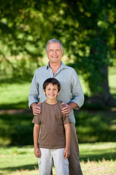 Grandather et son petit-fils regardant la caméra dans le parc — Photo