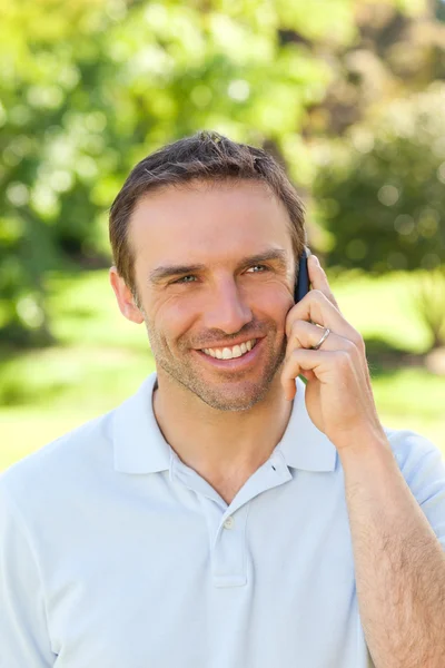 Schöner Mann telefoniert im Park — Stockfoto
