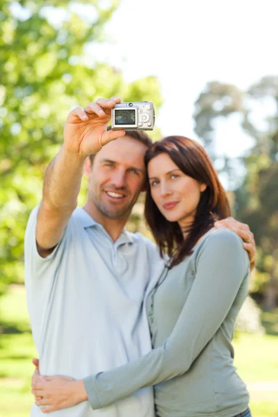 Casal tirando uma foto de si mesmos no parque — Fotografia de Stock