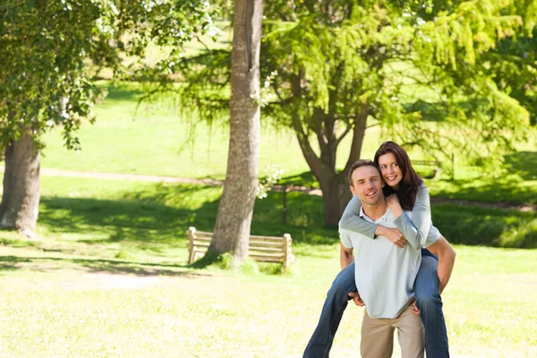 Man giving wife a piggyback — Stock Photo, Image