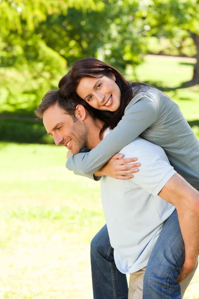 Hombre dando esposa un piggyback — Foto de Stock