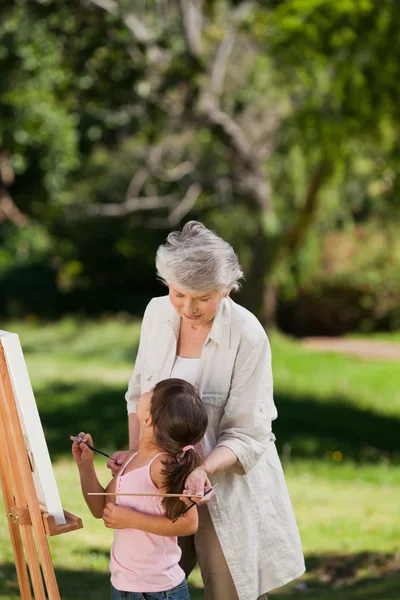Großmutter und Enkelin beim Malen im Garten — Stockfoto