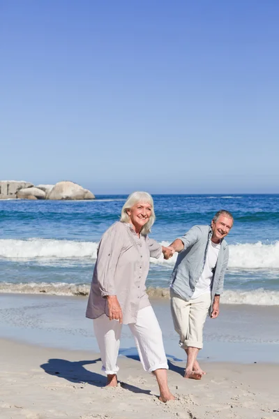 高齢者のカップル、ビーチの上を歩いて — ストック写真
