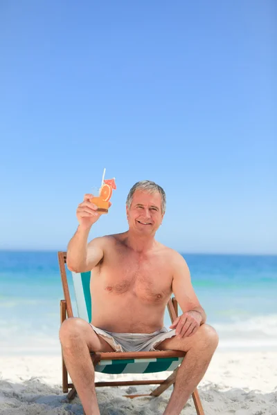 Sénior bebendo um coquetel na praia — Fotografia de Stock