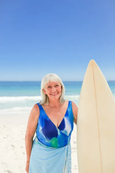 Mulher madura com sua prancha de surf — Fotografia de Stock