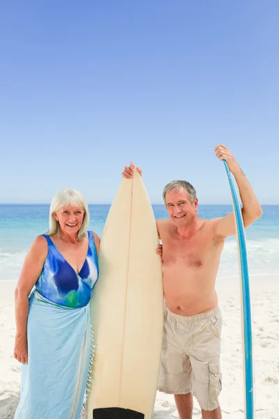 Mature couple with their surfboard — Stock Photo, Image