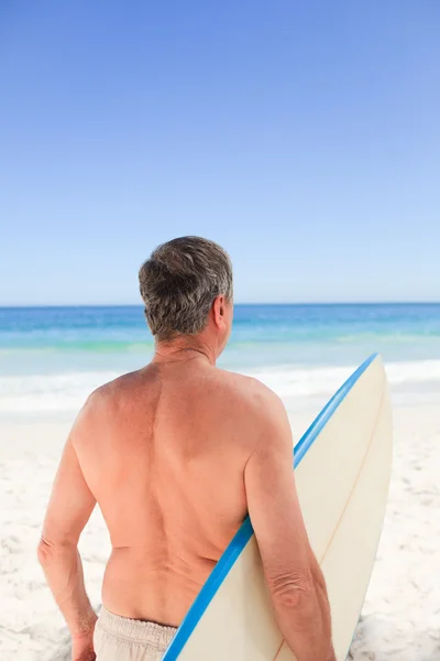 Senior man met zijn surfplank — Stockfoto