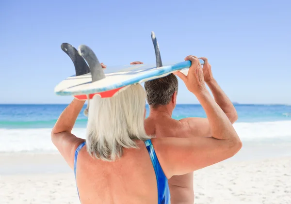 Senior koppel dat met hun surfplank — Stockfoto