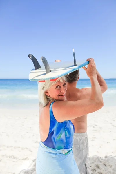 Äldre par med deras surfbräda — Stockfoto