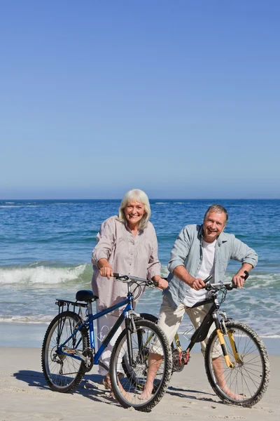 Ώριμο ζευγάρι με τα ποδήλατα τους στην παραλία — Φωτογραφία Αρχείου