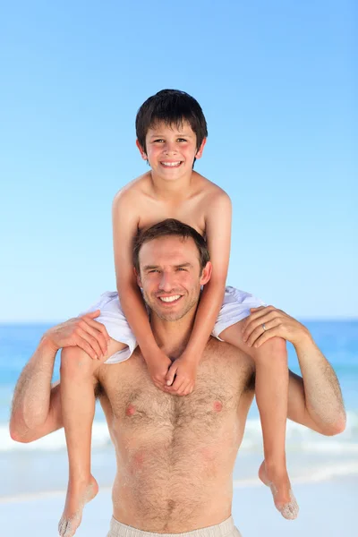 Vader zoon hebben een piggyback op het strand — Stockfoto