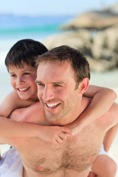 Vader zoon hebben een piggyback op het strand — Stockfoto