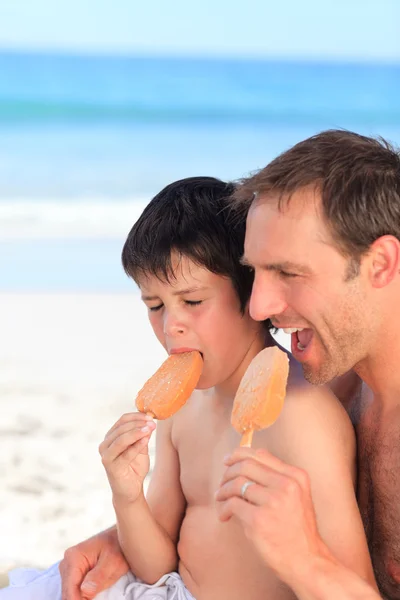 Отец ест мороженое со своим сыном — стоковое фото