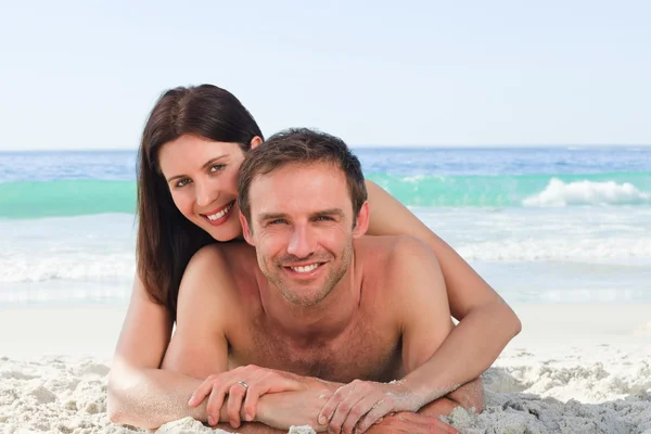 Couple lying down on the beach — Stock Photo, Image