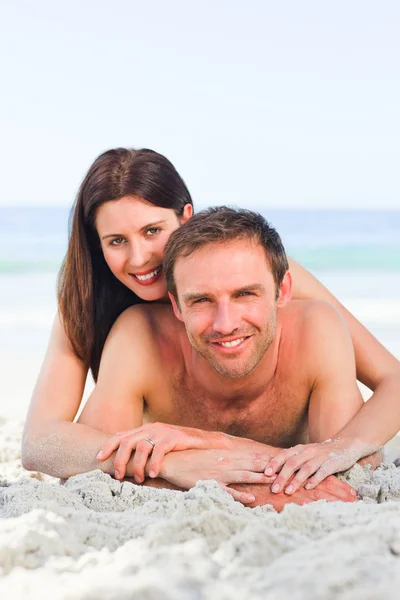Couple lying down on the beach — Stock Photo, Image