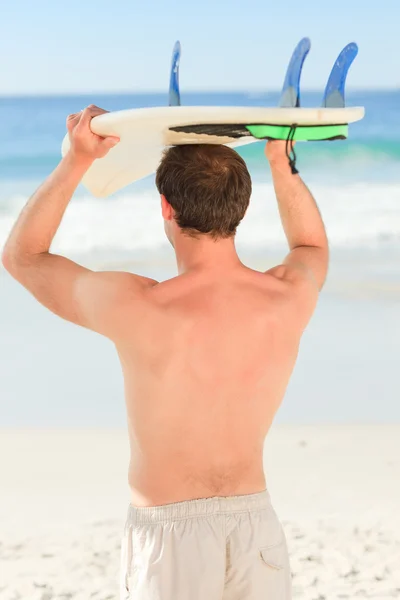 Schöner Mann mit seinem Surfbrett — Stockfoto