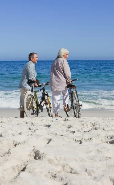 Старша пара з велосипедами на пляжі — стокове фото