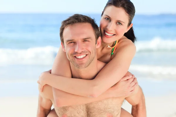 男子的妻子而背上海滩 — 图库照片