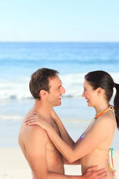 Schönes Paar, das sich am Strand umarmt — Stockfoto