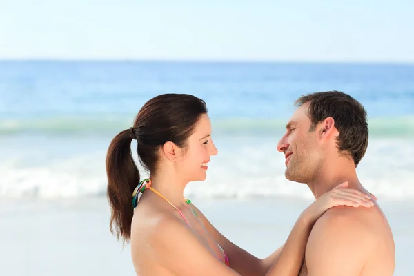 Entzückendes Paar, das sich am Strand umarmt — Stockfoto