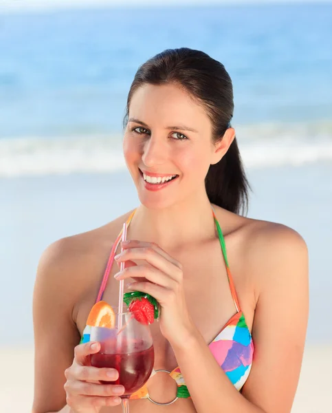 Vacker kvinna dricka cocktail på stranden — Stockfoto