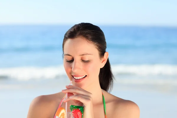 Güzel bir kadın sahilde kokteyl içiyor. — Stok fotoğraf