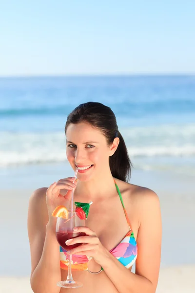 Hermosa mujer bebiendo cóctel en la playa — Foto de Stock