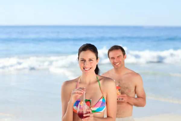 Couple drinking a cocktail on the beach — Stock Photo, Image