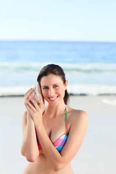 Woman listening to her shell — Stock Photo, Image
