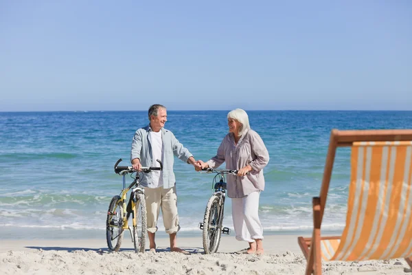 Idős házaspár a kerékpárjaikat a strandon — Stock Fotó