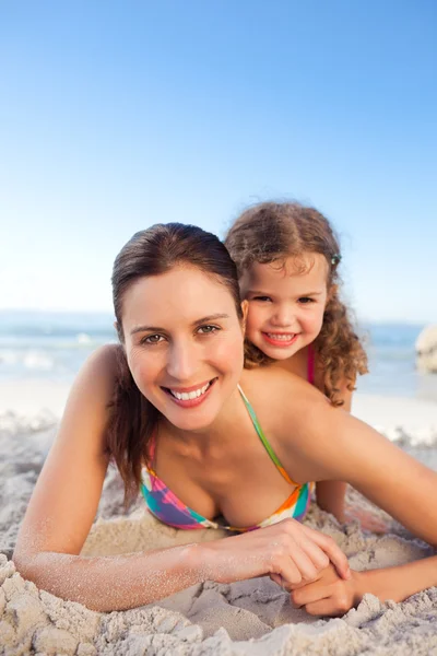Madre e hija acostadas en la playa —  Fotos de Stock