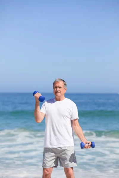 Człowiek robi swoje ćwiczenia na plaży — Zdjęcie stockowe