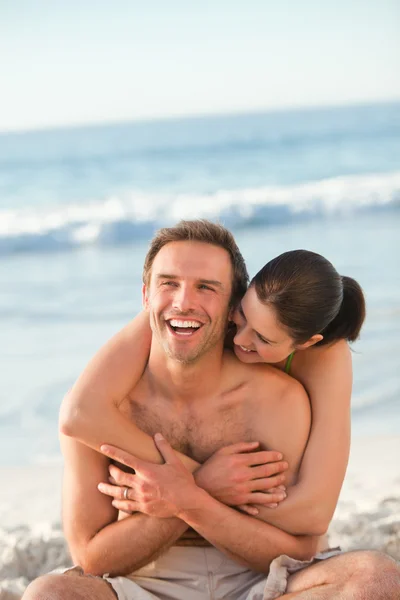 Esmerada pareja abrazándose en la playa —  Fotos de Stock