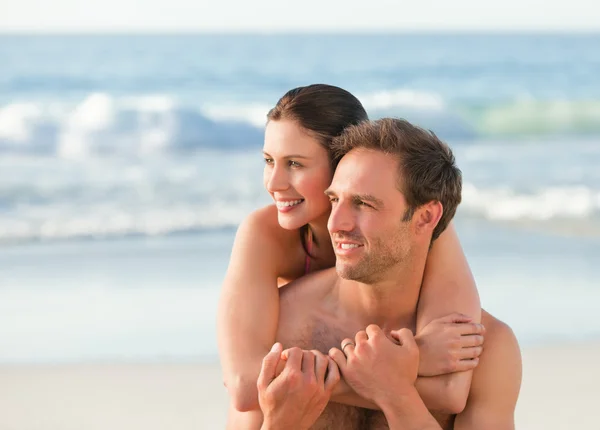 Förälskad par kramas på stranden — Stockfoto