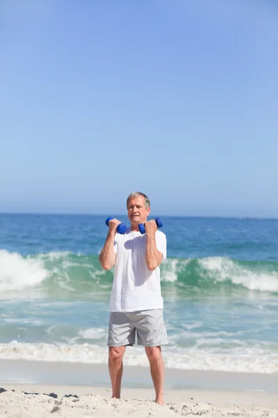 Člověk dělá jeho cvičení na pláži — Stock fotografie