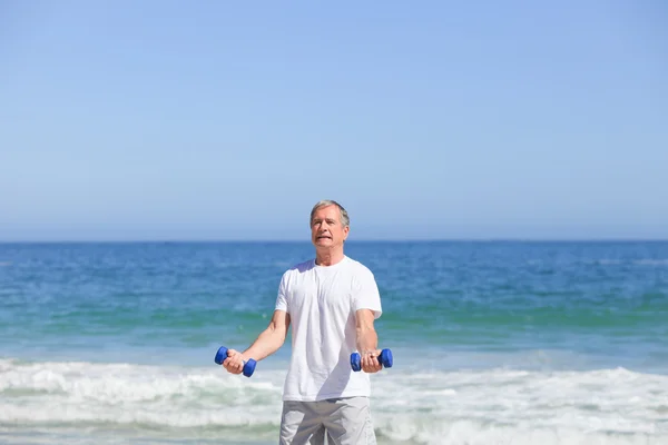 Man doen zijn oefeningen op het strand — Stockfoto