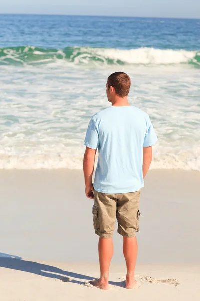 Knappe man wandelen op het strand — Stockfoto