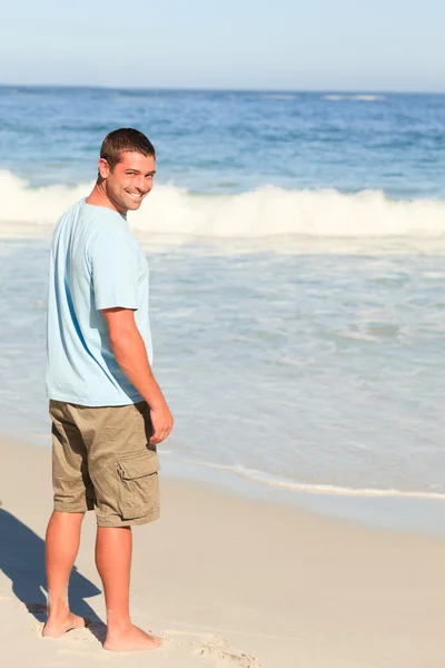 Schöner Mann zu Fuß am Strand — Stockfoto
